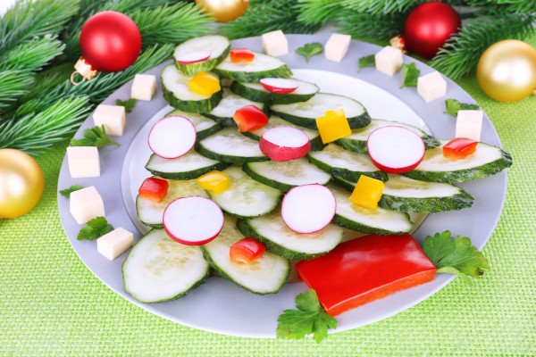 Овощной салат разложи на тарелке в виде наряженной елки.